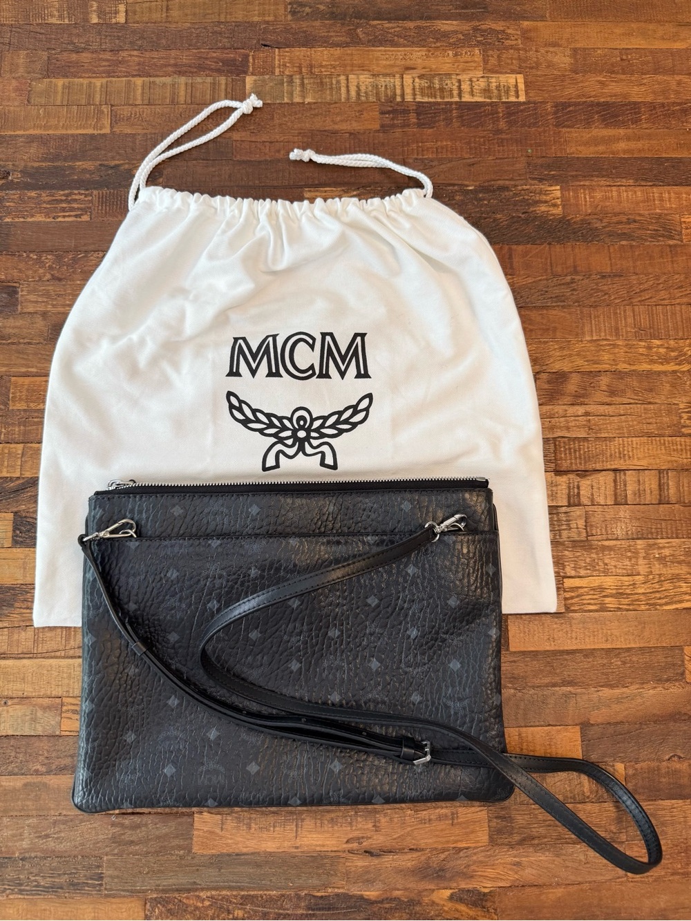 Black MCM Monogram Leather Crossbody Pouch with dust bag.